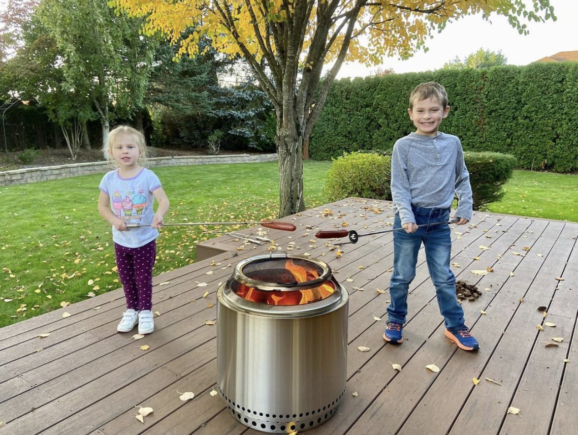 Children cooking hotdogs on a Solo Stove Fire Pit